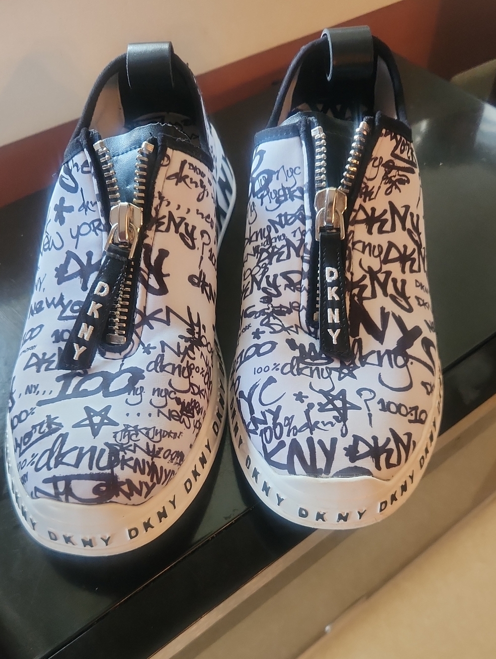 DKNY White and Black Graffiti Zip-Front Slip-On Sneakers with Branded Pull